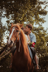 Fototapeta premium Young beautiful couple with a horse. Filtered. Selective focus.
