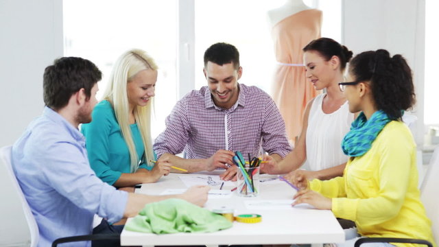smiling fashion designers working in office