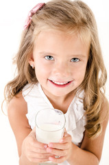 Smiling little girl drinking milk isolated on a white