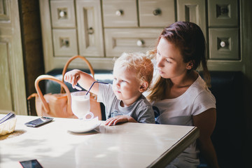 Young mother and her little son in a cafe