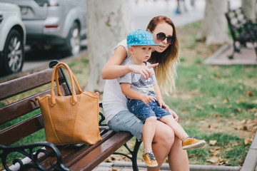 Fashion mother and son walking in a park
