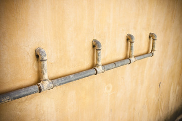 Old water pipes in front of wall