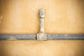 Old water pipes in front of wall