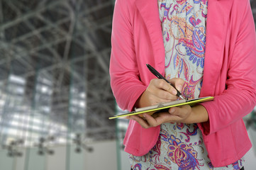 Businesswoman holding clipboard in meeting room