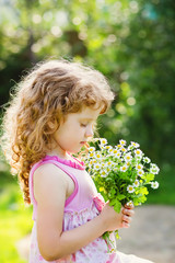 Happy child in a field with a bouquet of daisy. Toning photo.