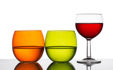 Water and wine - three glasses backlit. White background.
