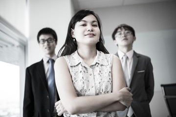 Happy business team with arms crossed at the office