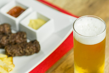 Traditional Romanian Mici And Fries With Mustard And Beer Glass
