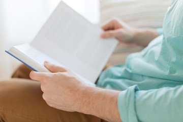 close up of man reading book at home