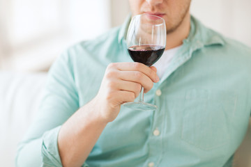 close up of man drinking wine at home