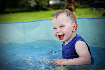 Fototapeta na wymiar Small boy playing in swimming pool
