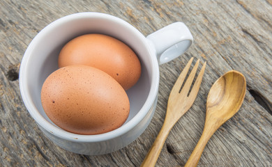 fresh eggs with cup and spoon wooden on table