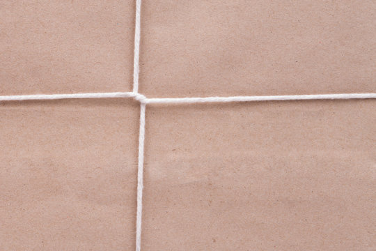 Background of white cardboard paper tied with twine