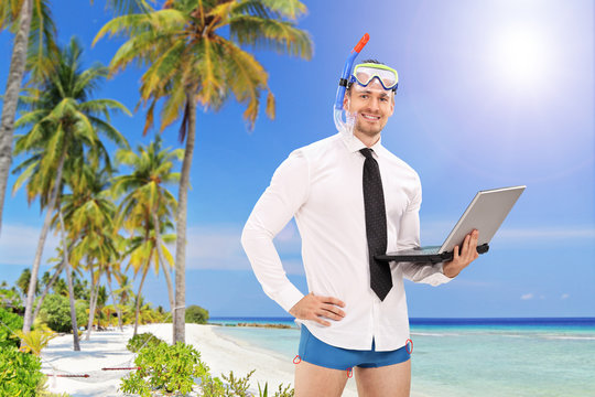 Businessman With A Diving Mask Holding A Laptop And Standing On