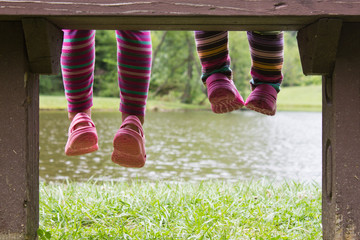 Little feet hanging from a bench at a pond