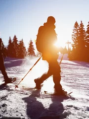 Wall murals Mountaineering snow shoe walking sillhouette