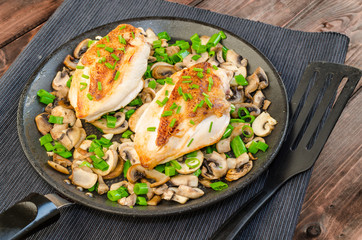 Chicken breast with mushrooms and spring onions on pan