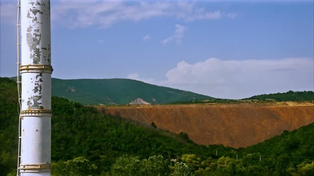 Clouds moving over a hill with a chimney in the foreground