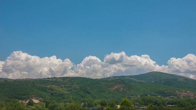 Clouds moving over a hill