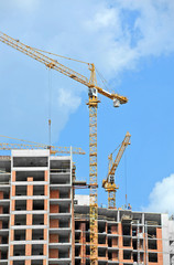 Crane and building construction site against blue sky