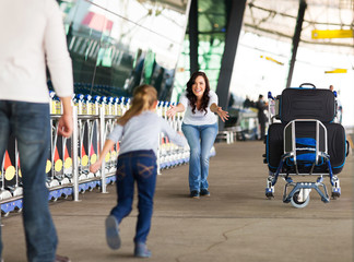young girl running to her mother at airport