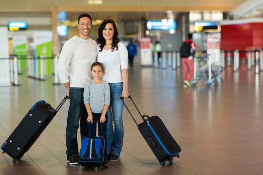 family with suitcases at airport