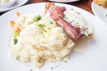 Mashed potatoes with crispy piece of bacon