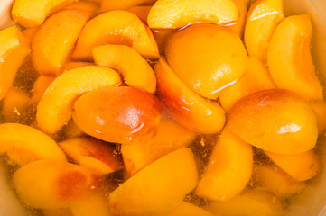 Bowl of fresh sliced peaches in syrup