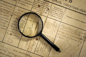old deed property and magnifying glass, selective focus