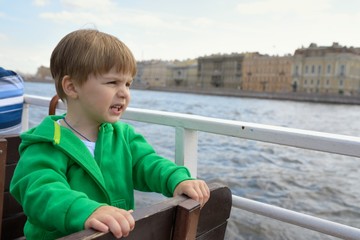 Fototapeta na wymiar Baby boy on boat looking on water