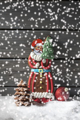 Lebkuchennikolaus auf Schnee vor Holzhintergrund