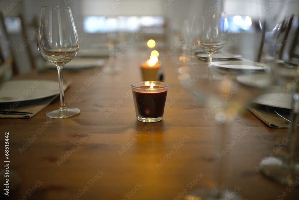 Wall mural covered dining table with wine glasses and candle