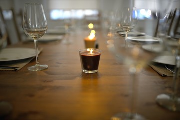 Covered dining table with wine glasses and candle
