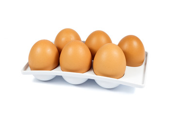 Six Brown Eggs in a White Plastic Package Isolated on White