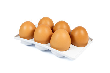 Six Brown Eggs in a White Plastic Package Isolated on White