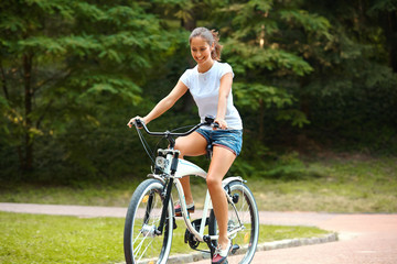 Naklejka premium Happy Woman is Cycling in Summer Park