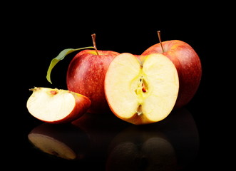 Close-up shot sliced red apple with leaf isolated