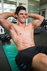 Determined muscular man doing abdominal crunches