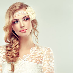 Beautiful model in lace dress with a pigtail and flower barrette