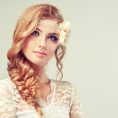 Beautiful model in lace dress with a pigtail and flower barrette