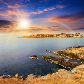 ancient city on a rocky shore near sea at sunset