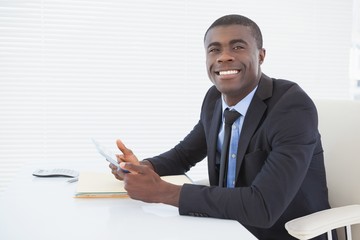 Happy businessman working with his tablet