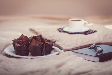 Chocolate muffins with coffee on bed