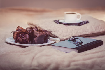 Book with sweet snacks on bed
