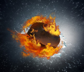 Burning puck with shards of ice on abstract background