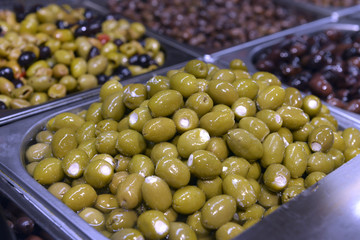 Green olives with cheese in a metal container in the store