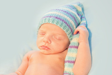 sweet newborn wearing striped long hat