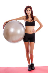 Fototapeta na wymiar Beautiful healthy young girl with a fitness ball 