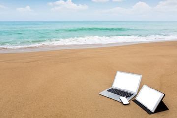Laptop ,tablet and smartphone on the beach in summer time
