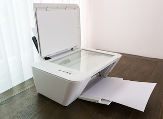 Printer with blank paper on a wood table